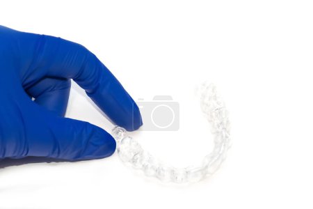 Photo for Orthodontist holds clear teeth aligners. Invisible braces teeth straighteners. Clear plastic bracers ready to use - Royalty Free Image