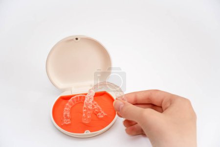 Photo for Transparent aligners retainers in a storage case. Invisible braces. Clear teeth straighteners. Plastic bracers - Royalty Free Image