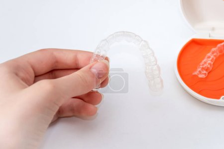 Transparent aligners retainers in a storage case. Invisible braces. Clear teeth straighteners. Plastic bracers
