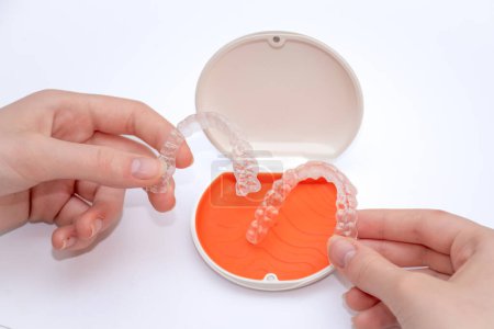 Photo for Transparent aligners retainers in a storage case. Invisible braces. Clear teeth straighteners. Plastic bracers - Royalty Free Image