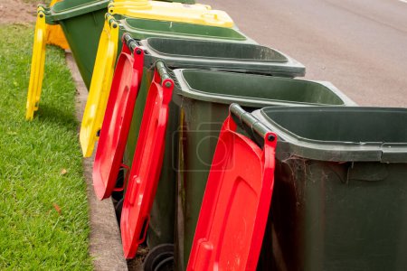 Photo for Australian garbage wheelie bins with colourful lids for general and recycling household waste on the street kerbside for council rubbish collection - Royalty Free Image