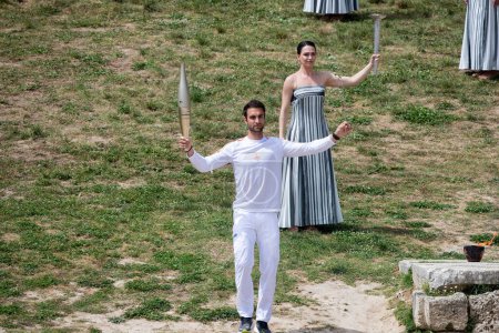 Photo for Olympia, Greece - April 15, 2024: Olympic flame lighting ceremony for the Paris 2024 Summer Olympic Games in Ancient Olympia, Greece. The first torch bearer, Greek olympic gold medalist Stefanos Douskos - Royalty Free Image