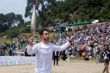Photo for Olympia, Greece - April 15, 2024: Olympic flame lighting ceremony for the Paris 2024 Summer Olympic Games in Ancient Olympia, Greece. The first torch bearer, Greek olympic gold medalist Stefanos Douskos - Royalty Free Image