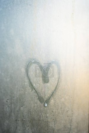 Photo for Heart shape drawing on fogged up glass outdoors. Love, romantic mood and Valentins day concept - Royalty Free Image