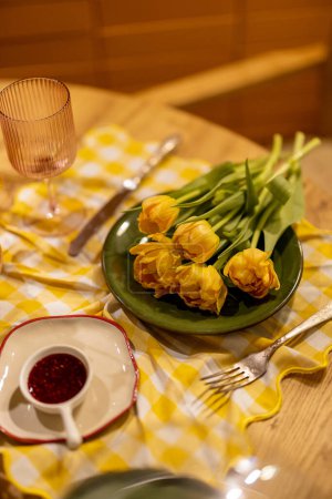 Téléchargez les photos : Tulipes sur assiette servies comme repas sur table à manger - en image libre de droit