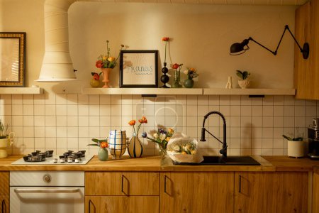 Téléchargez les photos : Intérieur de cuisine moderne en matériaux naturels avec façades en bois et étagères ouvertes décorées de fleurs. Décorations de maison et concept de design - en image libre de droit