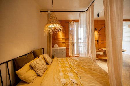 Téléchargez les photos : Vue intérieure de la chambre dans des tons beige avec abat-jour en paille et mur de briques - en image libre de droit