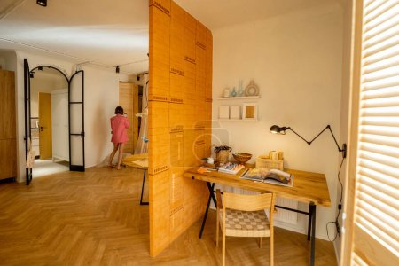 Foto de Vista interior del espacio de trabajo separado por una pared de ladrillo en un elegante apartamento estudio - Imagen libre de derechos