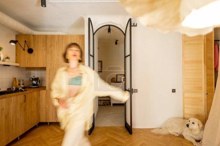 Téléchargez les photos : Studio élégant intérieur dans des tons beiges avec un mouvement flou silhouette féminine marche - en image libre de droit