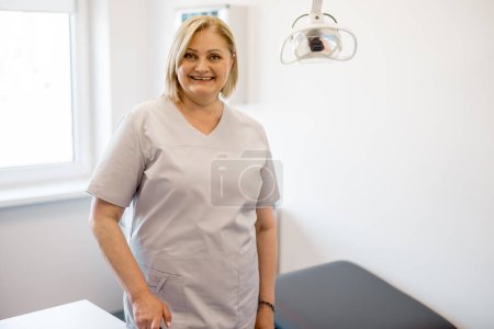 Foto de Retrato de la enfermera adulta en la oficina. Hermosa trabajadora médica caucásica con cabello rubio en la clínica - Imagen libre de derechos