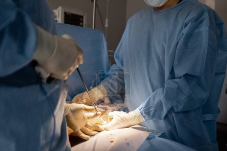 Téléchargez les photos : Deux chirurgiens opèrent la zone abdominale d'un patient. Concept d'opération réelle et d'intervention chirurgicale - en image libre de droit