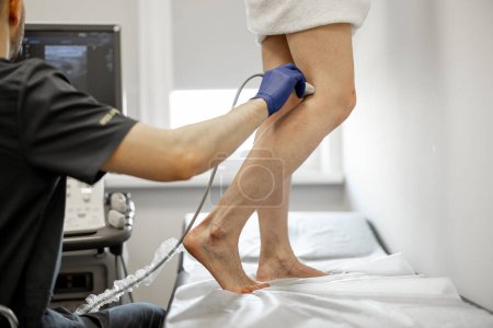 Photo for Ultrasound specialist is scanning the veins on a womans leg, examining veins for varicose treatment - Royalty Free Image