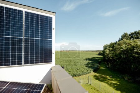 Foto de La azotea de una casa privada con una central solar en ella durante un día soleado, la naturaleza en el fondo - Imagen libre de derechos