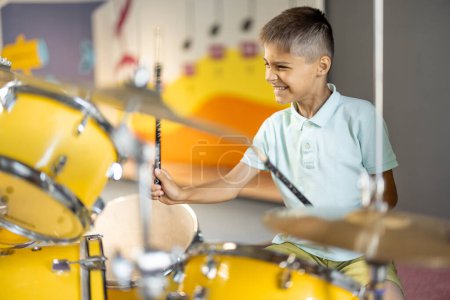 Photo for Little boy playing on a real drums, having fun while visiting a science museum - Royalty Free Image