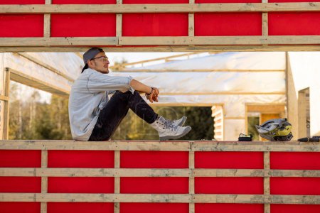 Foto de Hombre como constructor o carpintero en el sitio de construcción de una casa de marco de madera - Imagen libre de derechos