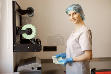 Téléchargez les photos : Le travailleur médical emballe les instruments médicaux stériles pour la chirurgie dans la salle de stérilisation de la clinique - en image libre de droit