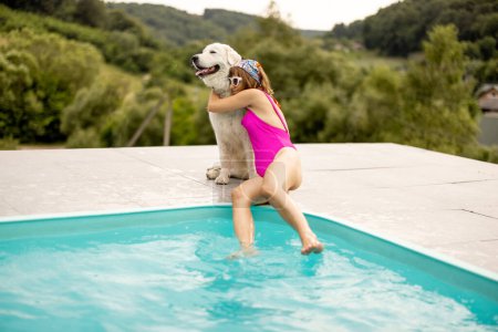 Téléchargez les photos : Femme repose avec son chien mignon près de la piscine, passer l'été ensemble. Concept d'amitié avec les animaux domestiques et vacances d'été - en image libre de droit