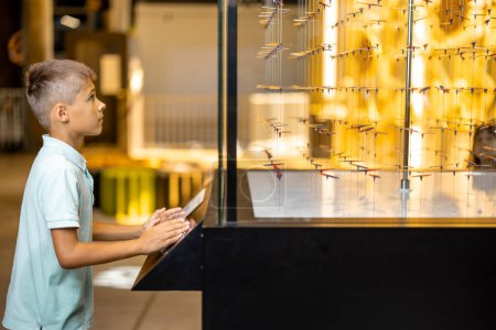 Foto de Niño estudiando física y campo magnético en un modelo interactivo en el museo de ciencias. Concepto de entretenimiento y aprendizaje infantil - Imagen libre de derechos