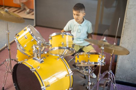 Téléchargez les photos : Petit garçon jouant sur un vrai tambour, s'amusant en visitant un musée des sciences - en image libre de droit