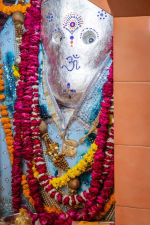 Photo for Hindu god ganesha idol worshiped with flowers vertical shot from flat angle image is taken at ganesh temple ratanada jodhpur rajasthan india. - Royalty Free Image