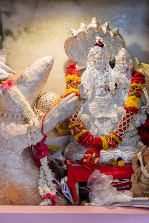 Photo for Hindu lord shiva and parvati made of silver worshiped with flowers vertical shot from flat angle image is taken at ganesh temple ratanada jodhpur rajasthan india. - Royalty Free Image