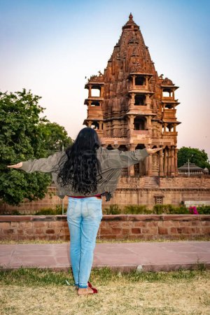 Photo for Ancient hindu temple architecture with girl witnessing it at evening from flat angle at day - Royalty Free Image