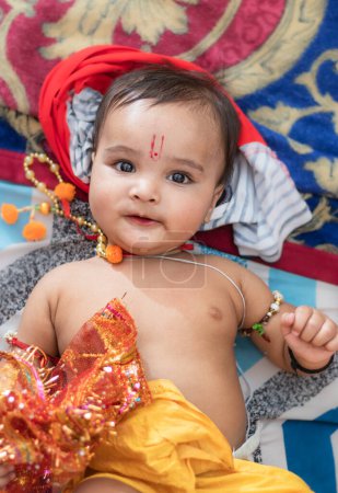 Téléchargez les photos : Mignon indien garçon robes comme seigneur rama avec arc et fleurs de l'angle supérieur - en image libre de droit