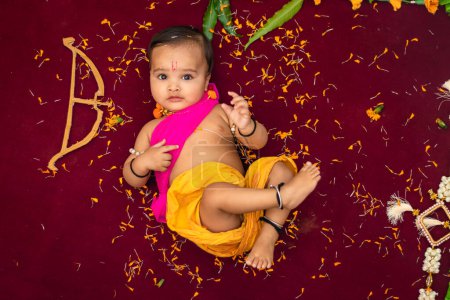 Téléchargez les photos : Mignon indien garçon robes comme seigneur rama avec arc et fleurs de l'angle supérieur - en image libre de droit