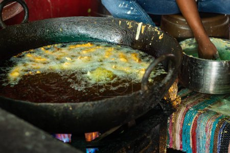 Téléchargez les photos : Friture de gros chili à l'huile rassemblée au magasin de rue ou Mirchi badda plats locaux de l'Inde à la rue - en image libre de droit