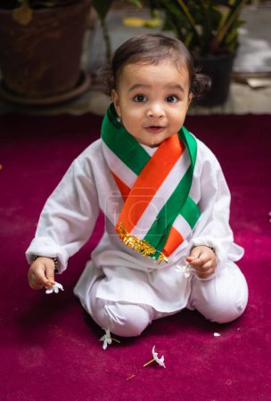 Photo for Cute toddler holding indian tricolor flag in traditional cloth with innocent facial expression - Royalty Free Image