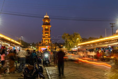 Foto de Torre del reloj histórico arquitectura antigua en la ciudad con la muchedumbre larga exposición luz senderos disparo imagen se toma en el mercado de sardar ghantaGhar jodhpur rajasthan india el Nov 06 2023. - Imagen libre de derechos