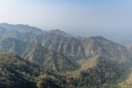 misty mountain range covered with fog at morning from flat angle image is taken at Kumbhal fort kumbhalgarh rajasthan india.