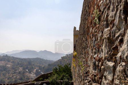 misty mountain with fort stone wall at morning from flat angle image is taken at Kumbhal fort kumbhalgarh rajasthan india.