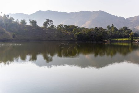 isolated mountain range with pristine lake reflection at morning from flat angle