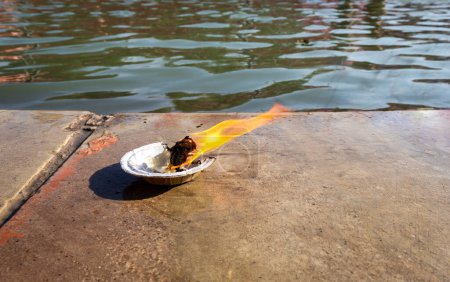 ofrendas sagradas lámpara de aceite en la orilla del río en ocasión religiosa por la mañana desde el ángulo plano