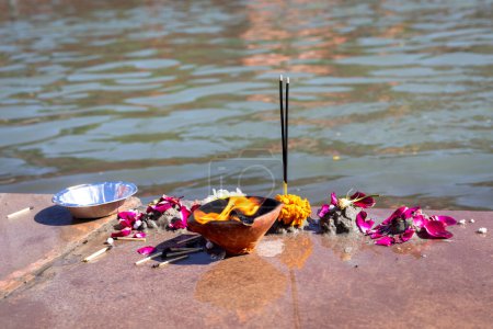 holy offerings by devotee at religious river shore at morning from flat angle