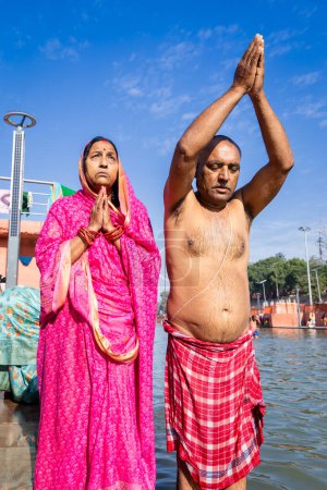 devotee couple praying after bathing in holy river water at morning from flat angle