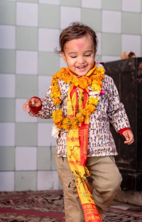 cute kid wearing holy garland at temple from flat angle