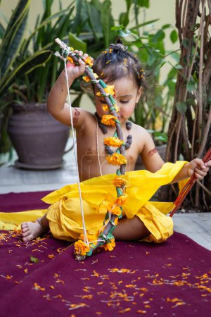 Portrait of cute Indian boy dresses as lord rama with bow at outdoor with blurred background at day