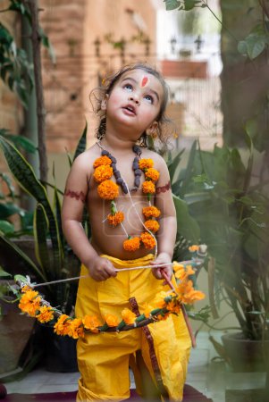 Portrait de mignon indien garçon robes comme seigneur rama avec arc à l'extérieur avec fond flou le jour
