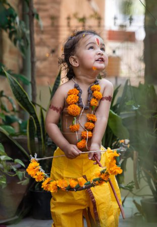 Retrato de lindos vestidos de niño indio como lord rama con lazo al aire libre con fondo borroso en el día