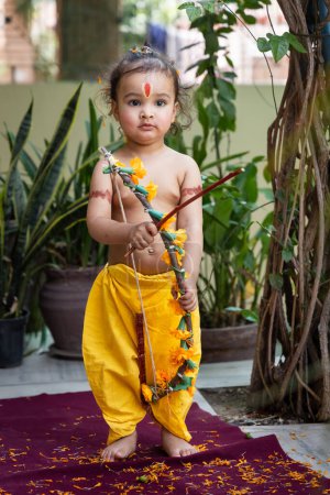 Retrato de lindos vestidos de niño indio como lord rama con lazo al aire libre con fondo borroso en el día