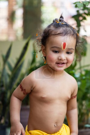 niedlicher indischer Junge mit heiligem religiösen Symbol auf dem Kopf im Freien mit verschwommenem Hintergrund