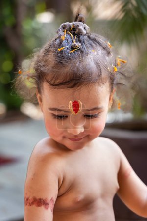 lindo chico indio con santo símbolo religioso en la cabeza al aire libre con fondo borroso