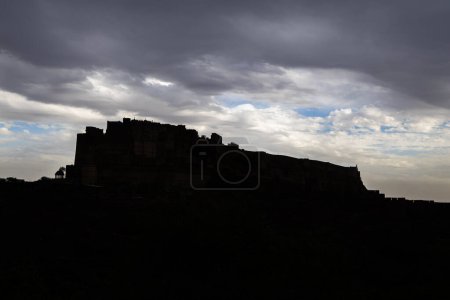 Gegenlichtaufnahme der alten historischen Festung mit dramatischem bewölkten Himmel am Abend aus verschiedenen Blickwinkeln Bild wird bei mehrangarh Fort Jodhpur Rajasthan Indien aufgenommen.