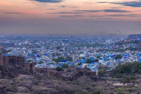 blue city view with dramatic sunset sky at evening from flat angle image is taken at mehrangarh fort jodhpur rajasthan india.