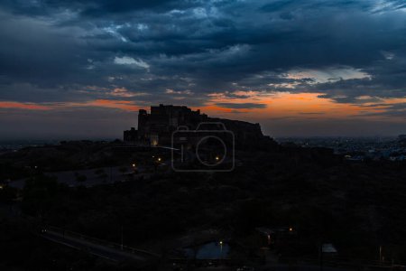 backlit shot of ancient historical fort with dramatic sunset sky at dusk from flat angle image is taken at mehrangarh fort jodhpur rajasthan india.
