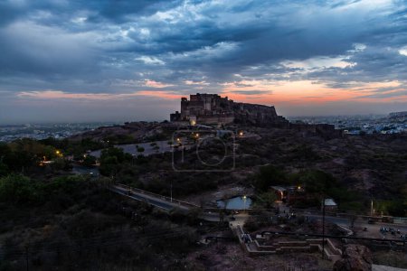 ancient historical fort with dramatic sunset sky at dusk from flat angle image is taken at mehrangarh fort jodhpur rajasthan india.