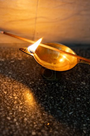 holy copper oil lamp burning with incense stick at home offerings for almighty god at night