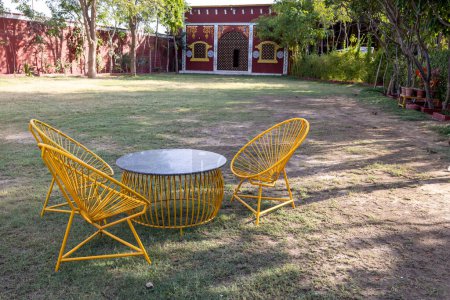 isolated iron chair and table sitting at outdoor garden grass at evening
